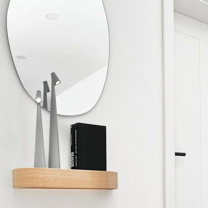 Smala bordslampor på hylla med spegel