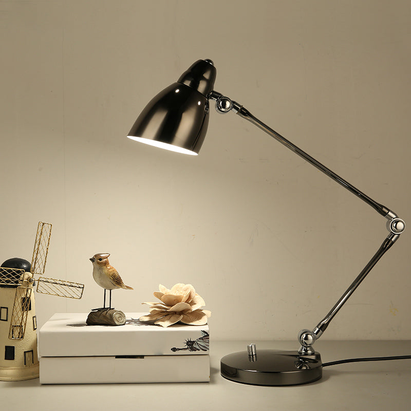 Svart justerbar skrivbordslampa på bord