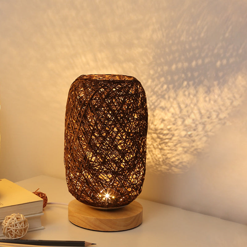 Mörk bordslampa med vävd design och varmt ljus