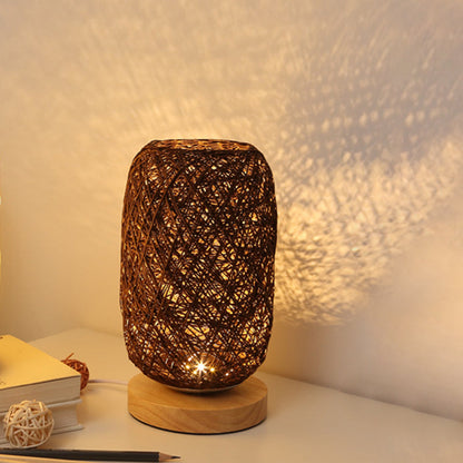 Mörk bordslampa med vävd design och varmt ljus
