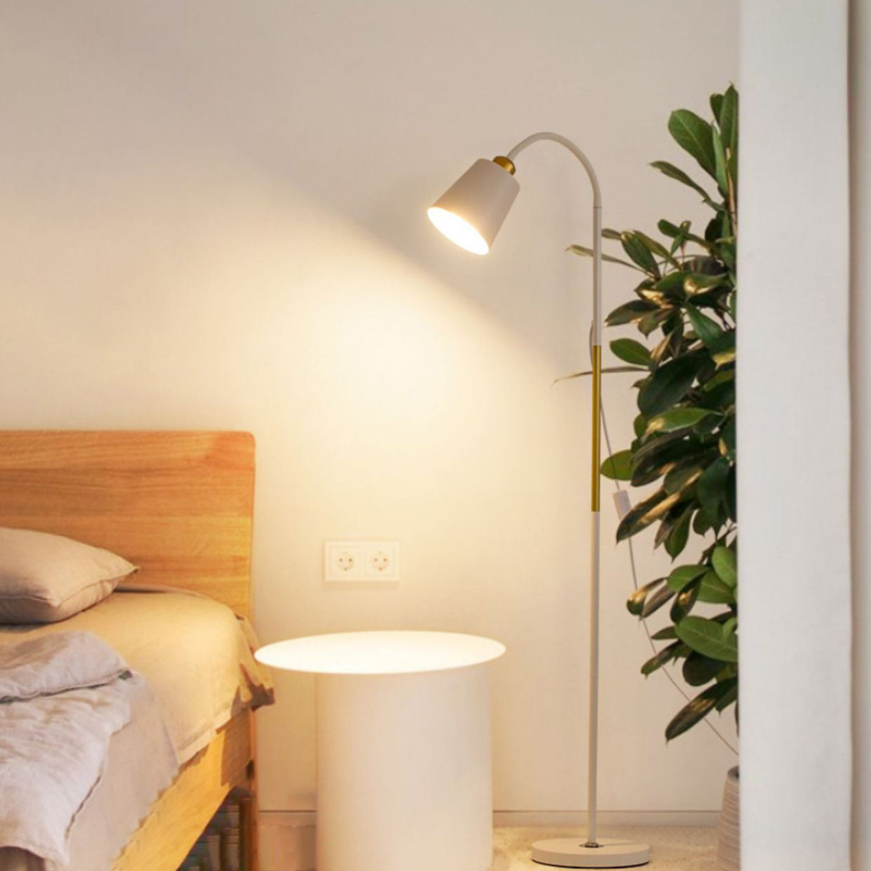 Golvlampa med ljust ljus bredvid säng