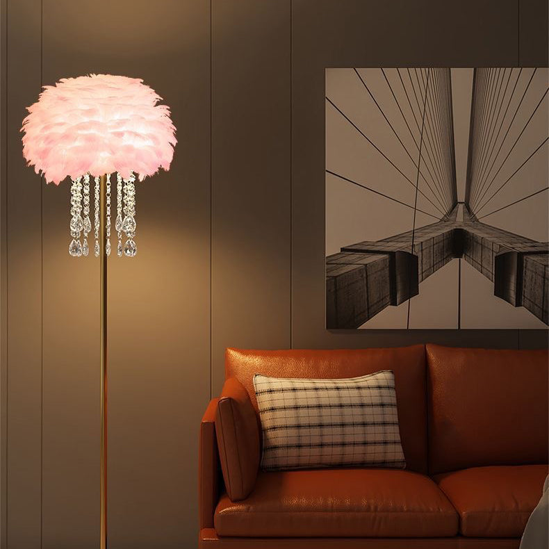 Golvlampa med rosa lampskärm bredvid soffa