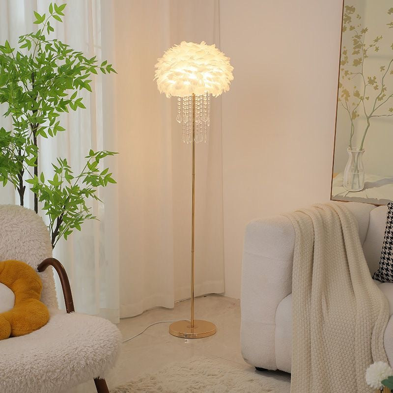 Elegant golvlampa med ljus lampskärm bredvid soffa
