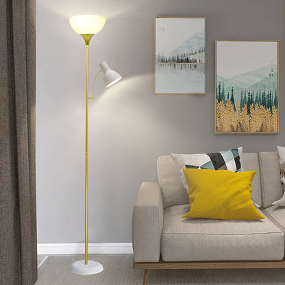 Guld golvlampa med uplight vid soffa