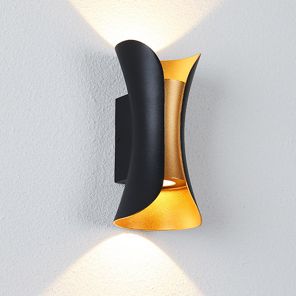 Närbild på svart och guld vägglampa på vägg