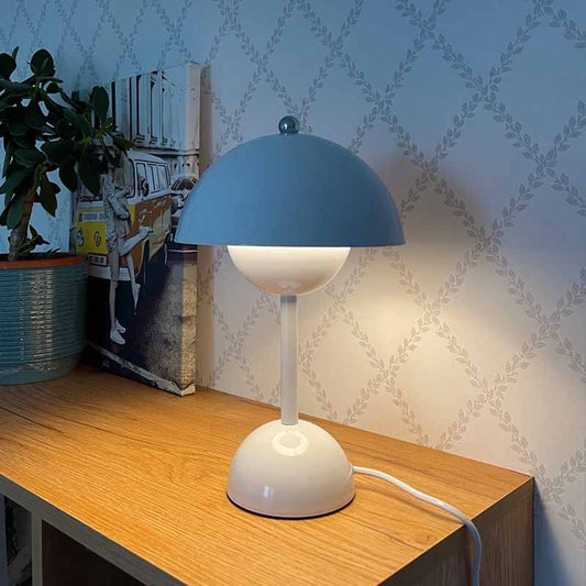 Blå bordslampa med rund lampskärm på träbord