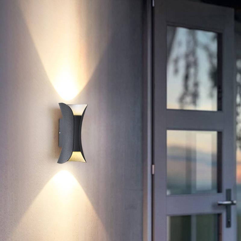 Närbild på vit och guld vägglampa på vägg