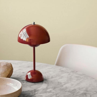 Röd bordslampa med rund lampskärm på marmorbord