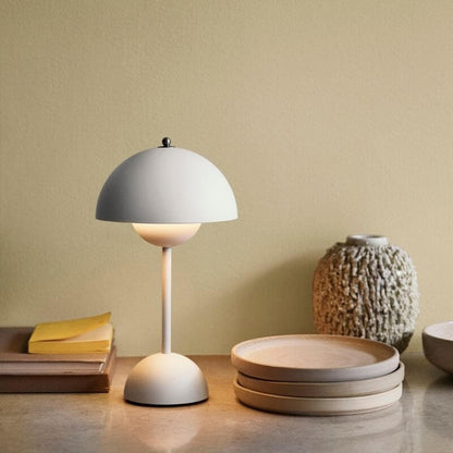 Beige bordslampa med varmt ljus på bord